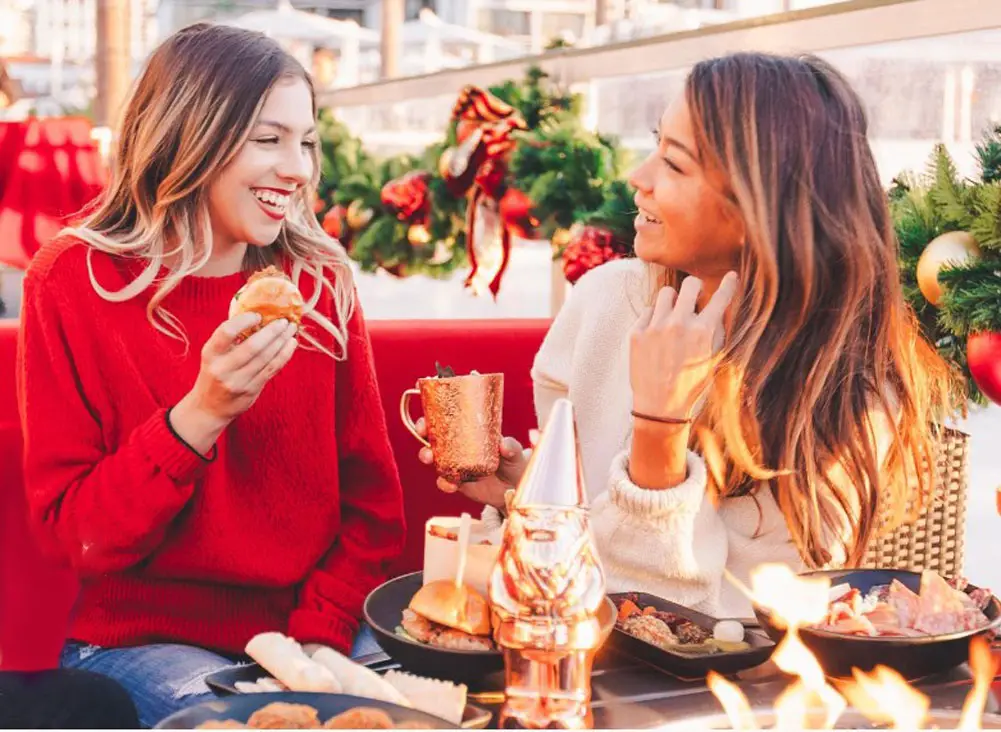 Two women eating and drinking at the Frostbite Lounge at Hotel del Coronado